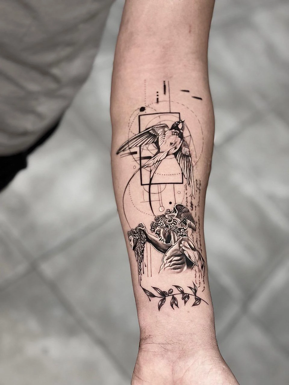 Fineline anatomisk hjerte med fugl og olivenkvist på underarm