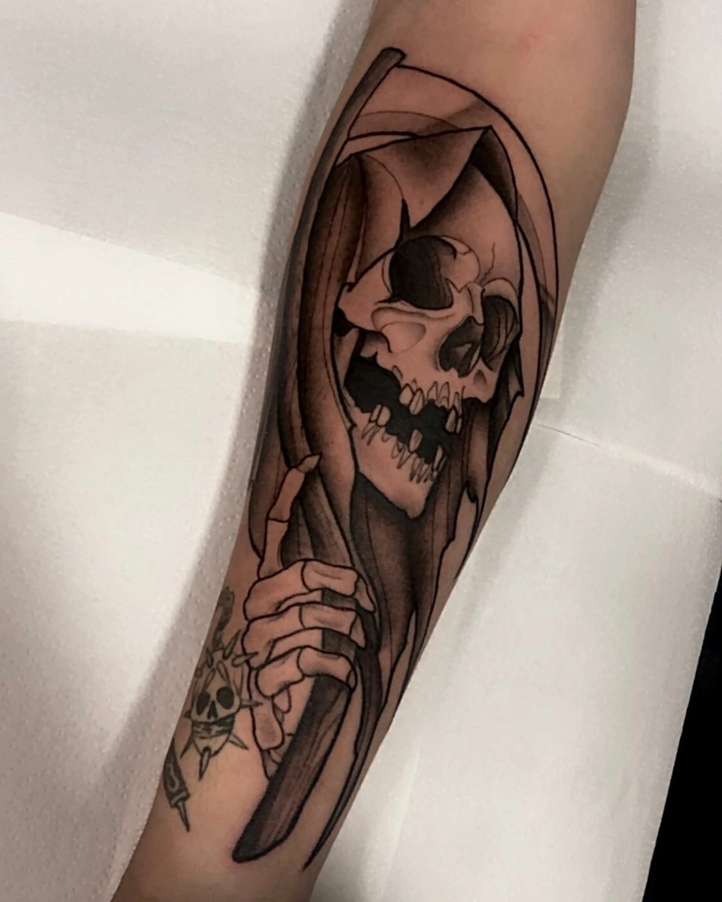 Hooded grim reaper skull with scythe