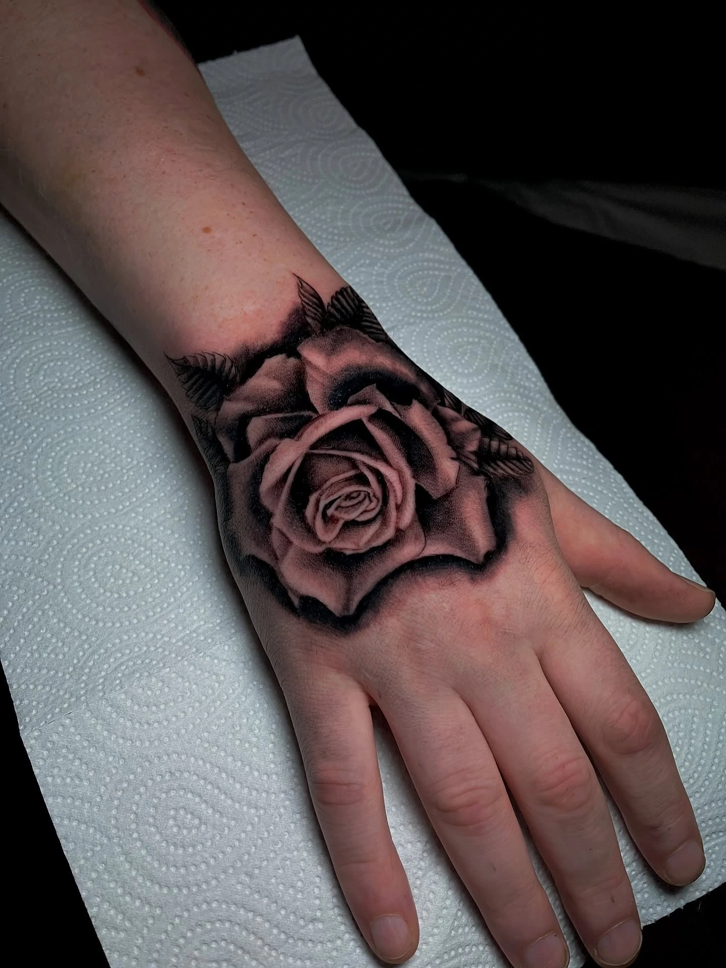 Hyperrealistic black & grey rose on the hand (close-up)