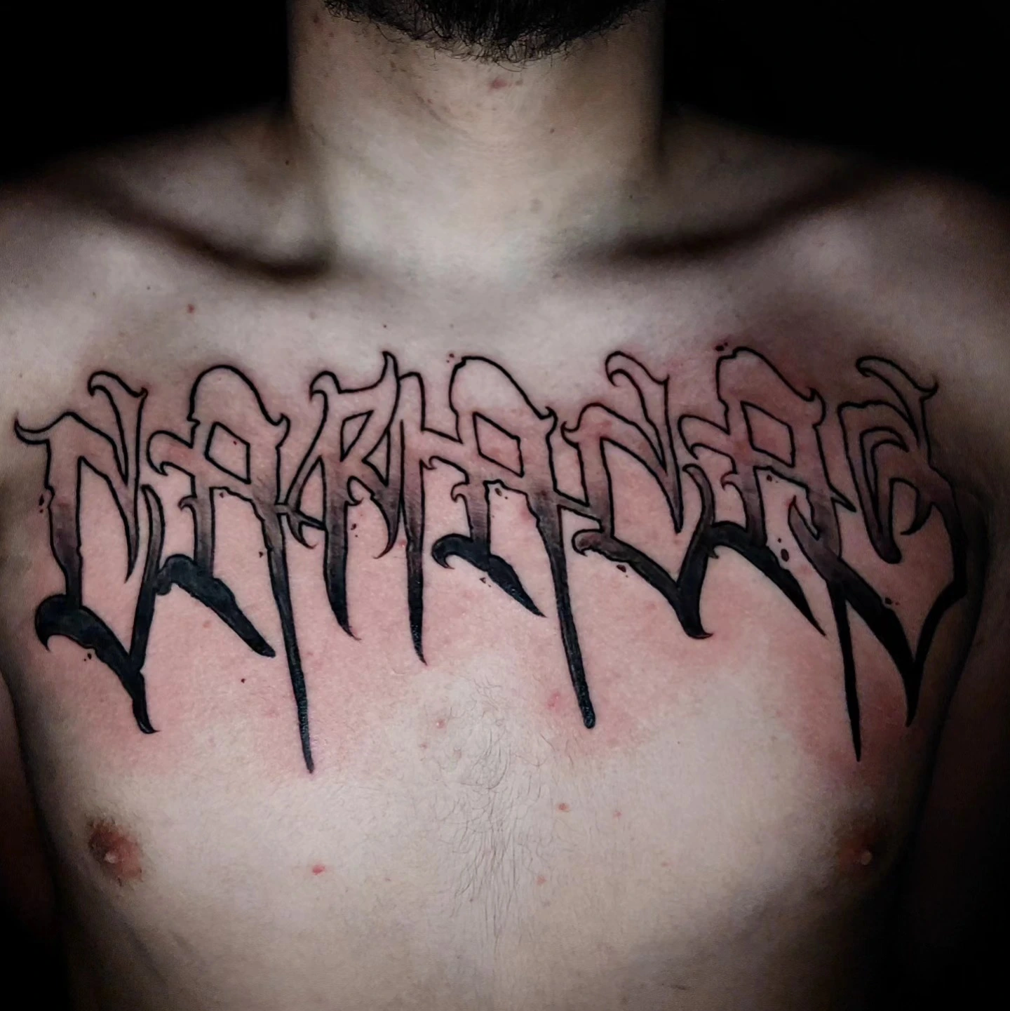 Chicano blackletter chest piece (outline-heavy 3D)