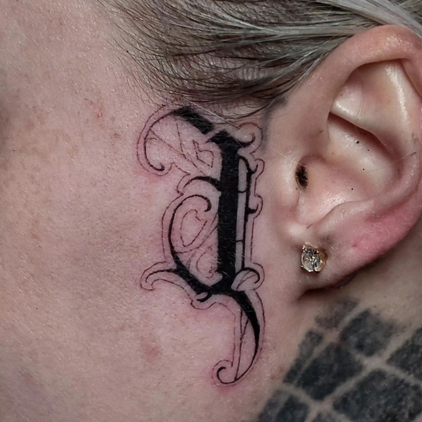 Heavy black trident/spike chin script under jaw