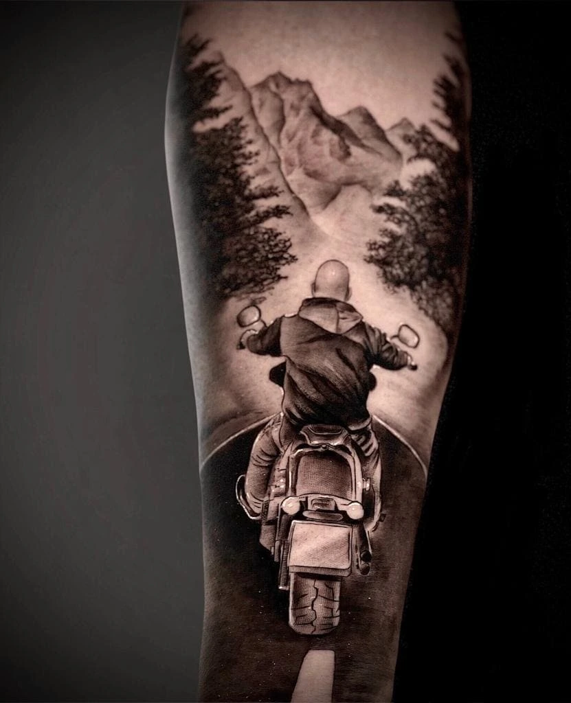 mountain landscape with motorcycle rider riding away into mountains