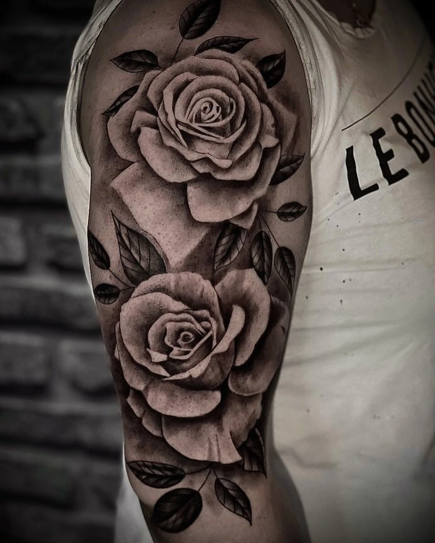 two photoreal black-and-grey roses on upper arm
